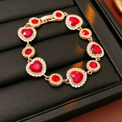 Crimson Heart Luxe Collection with red heart gemstone necklace, bracelet, and earrings, accented with pavé details