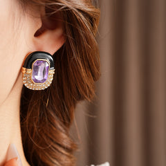 Black enamel stud earrings with amethyst-tone crystal and rhinestone frame — Midnight Amethyst Radiance Earrings.