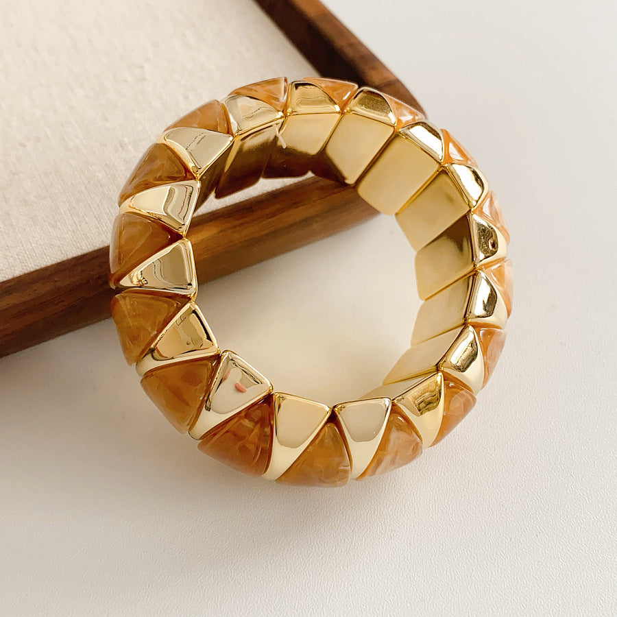 Gold-tone segmented bangle with marbled acrylic dome tiles — Gilded Capsule Resin Bangle.