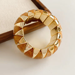 Gold-tone segmented bangle with marbled acrylic dome tiles — Gilded Capsule Resin Bangle.