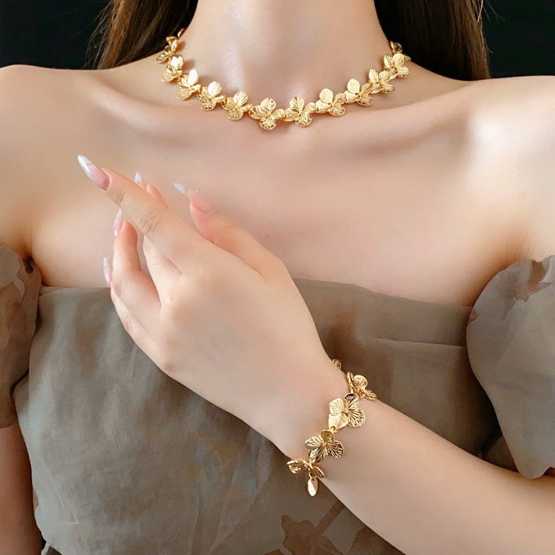 Golden Petal Elegance Set with necklace, bracelet, and earrings featuring golden floral petal details