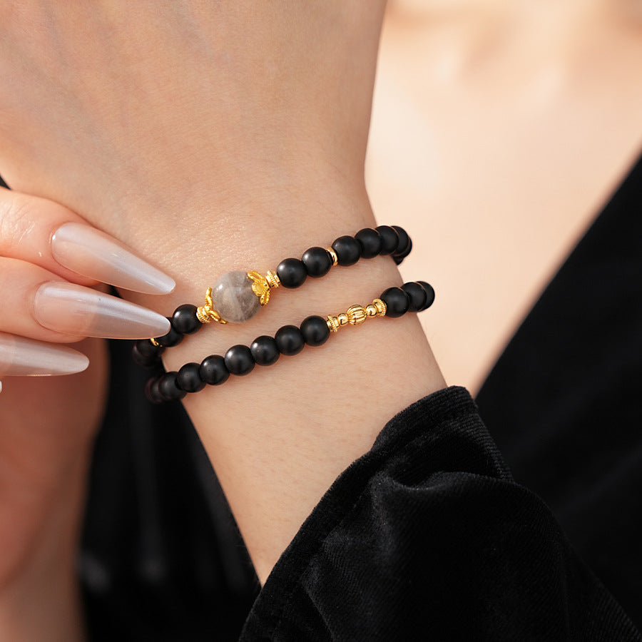 Black sandstone double-wrap bracelet with gray moonstone focal and gold accents — Midnight Moonstone Wrap Bracelet.