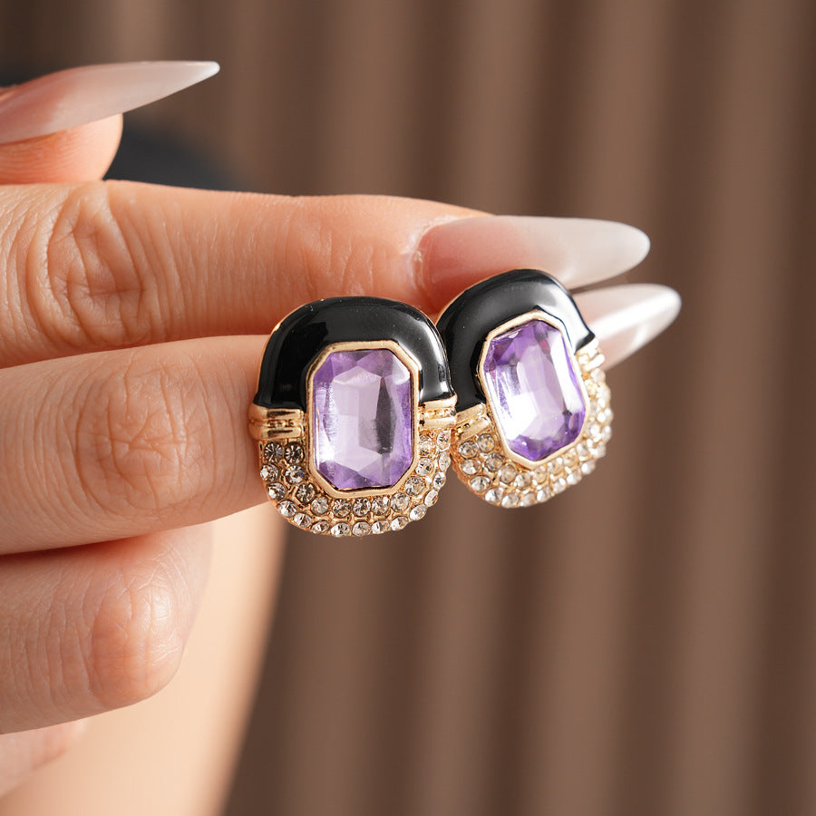 Black enamel stud earrings with amethyst-tone crystal and rhinestone frame — Midnight Amethyst Radiance Earrings.