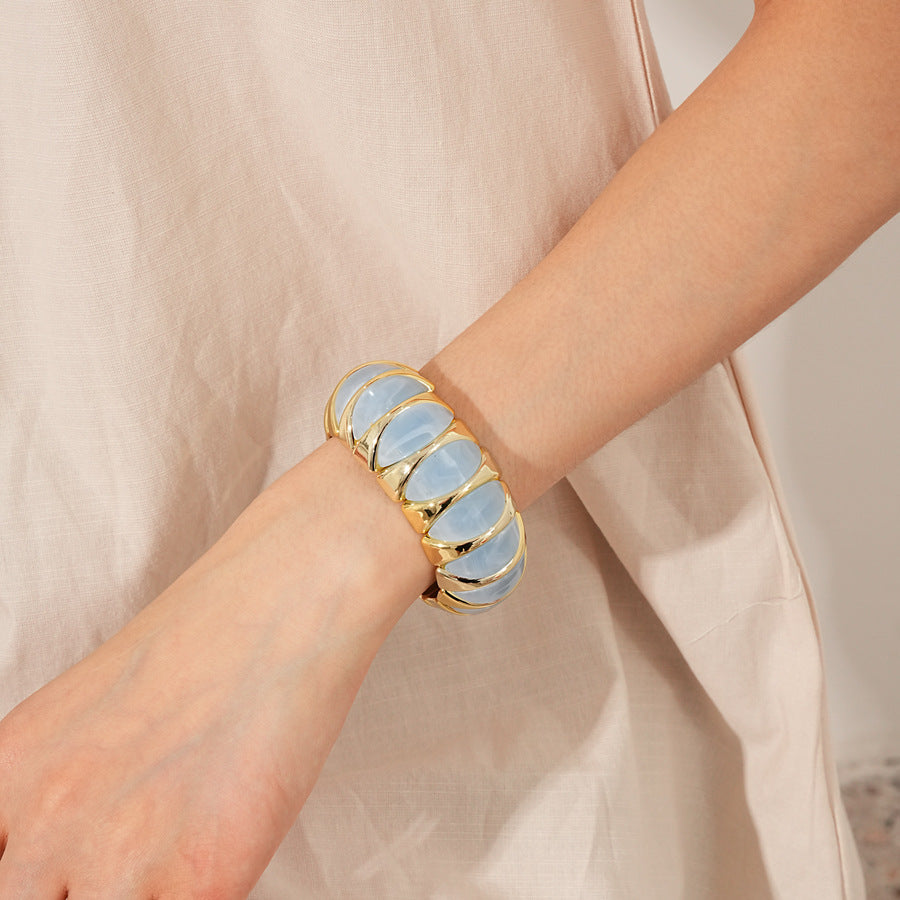 Gold-tone segmented bangle with marbled acrylic dome tiles — Gilded Capsule Resin Bangle.
