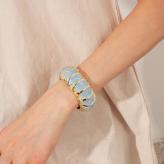 Gold-tone segmented bangle with marbled acrylic dome tiles — Gilded Capsule Resin Bangle.