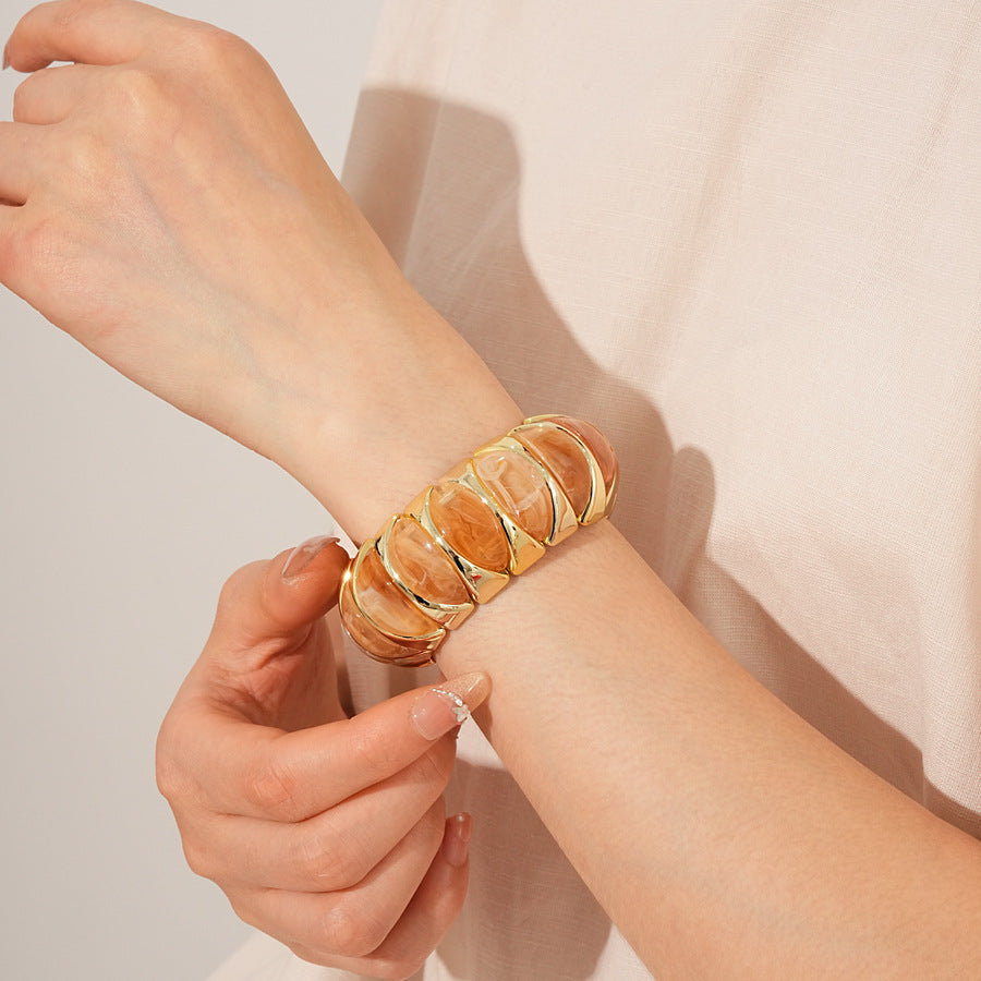 Gold-tone segmented bangle with marbled acrylic dome tiles — Gilded Capsule Resin Bangle.