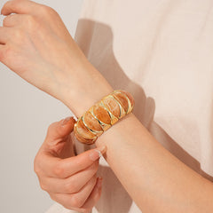 Gold-tone segmented bangle with marbled acrylic dome tiles — Gilded Capsule Resin Bangle.