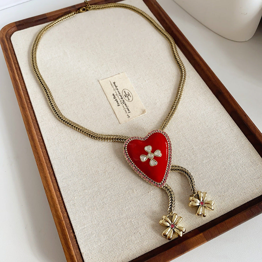 Lariat necklace with beaded-edge heart pendant and twin tassel blossoms on model — Regal Heart Tassel Lariat Necklace.