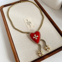 Lariat necklace with beaded-edge heart pendant and twin tassel blossoms on model — Regal Heart Tassel Lariat Necklace.