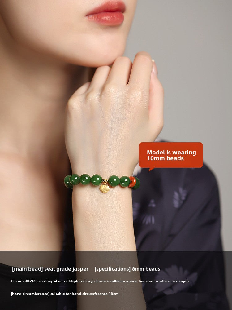 Green Hetian (nephrite) jade bead bracelet with red spacer and gold-tone charm