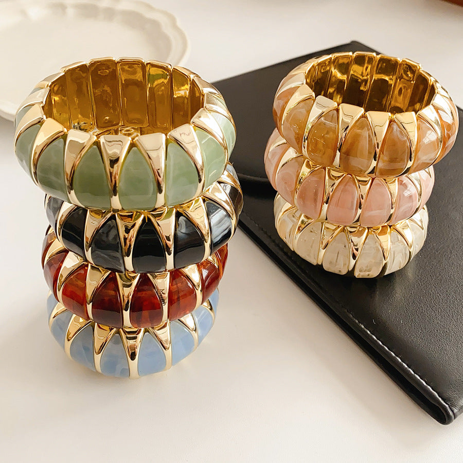Gold-tone segmented bangle with marbled acrylic dome tiles — Gilded Capsule Resin Bangle.