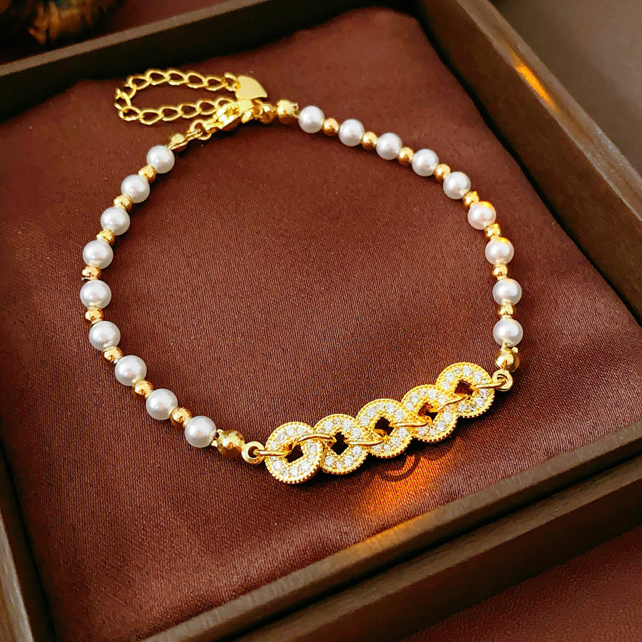 Gold link and pearl chain bracelet with zircon accents on green velvet background – Celestial Pearl Chain Bracelet by Glazenya