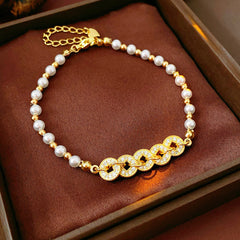 Gold link and pearl chain bracelet with zircon accents on green velvet background – Celestial Pearl Chain Bracelet by Glazenya