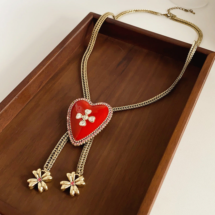 Lariat necklace with beaded-edge heart pendant and twin tassel blossoms on model — Regal Heart Tassel Lariat Necklace.