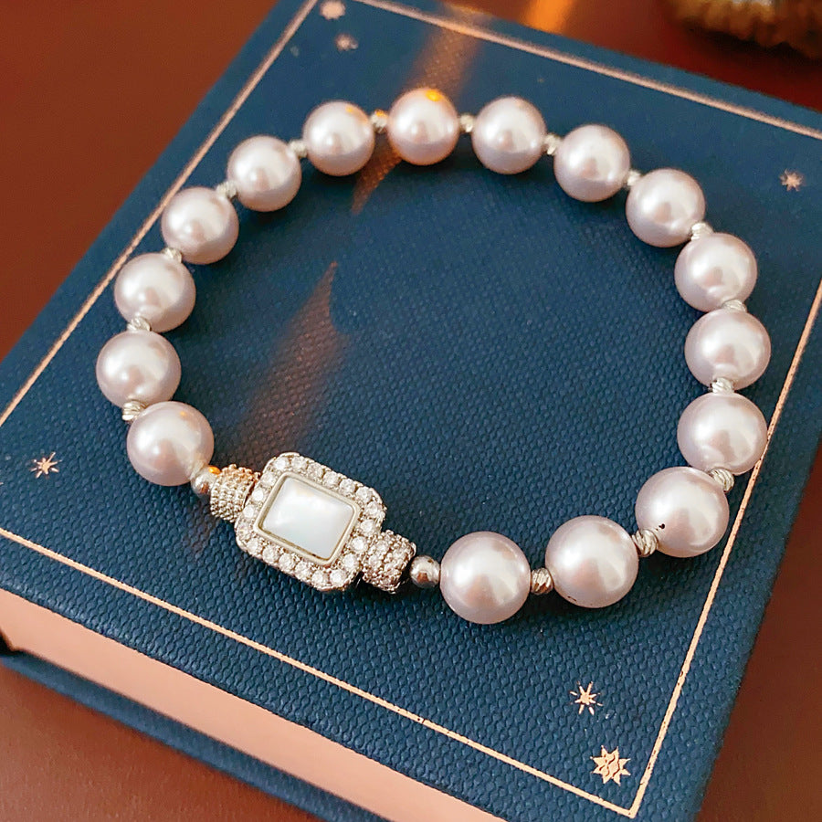 Deco Halo Pearl Bracelet featuring luminous pearls and a pavé-framed rectangular mother-of-pearl charm.
