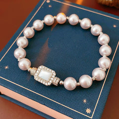 Deco Halo Pearl Bracelet featuring luminous pearls and a pavé-framed rectangular mother-of-pearl charm.
