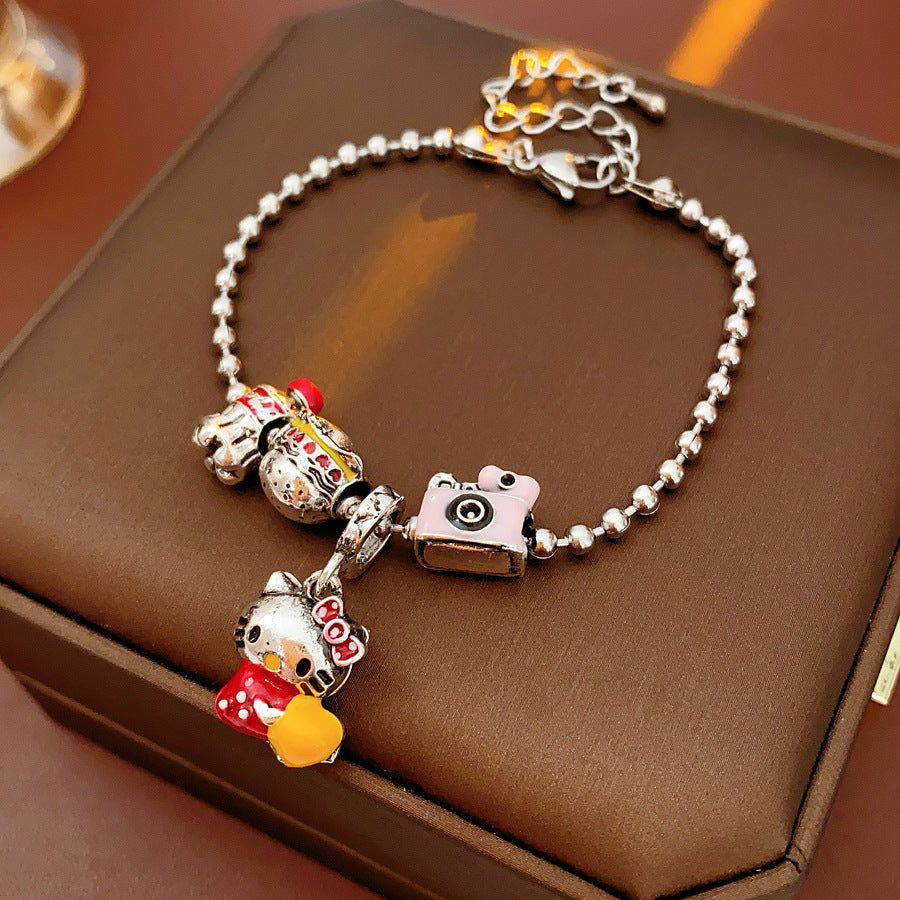 Kawaii Charm Story Bracelet with cartoon cat, burger, camera, and bell charms on silver-tone bead chain