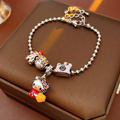 Kawaii Charm Story Bracelet with cartoon cat, burger, camera, and bell charms on silver-tone bead chain