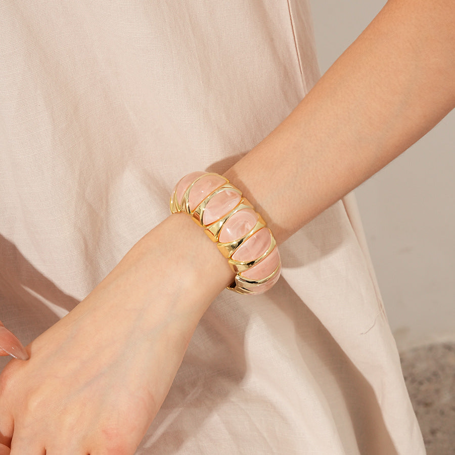 Gold-tone segmented bangle with marbled acrylic dome tiles — Gilded Capsule Resin Bangle.