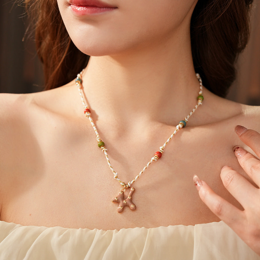 Boho ceramic charm rope necklace with multicolor beads and tan enamel pendant on cotton cord