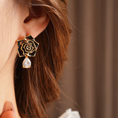 Gold-tone rose stud earrings with ivory and black enamel petals plus teardrop zircon dangles — Gilded Rose Teardrop Studs.