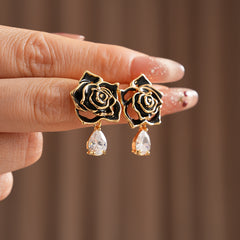 Gold-tone rose stud earrings with ivory and black enamel petals plus teardrop zircon dangles — Gilded Rose Teardrop Studs.